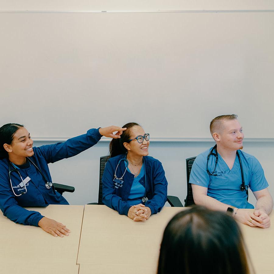 Nursing students in scrubs take a seminar.